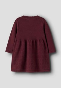 Robe tricotée bordeaux avec des manches longues, un bustier texturé et une jupe froncée. Encolure côtelée ; motif complexe sur la partie jupe.