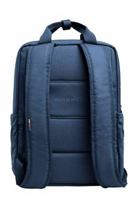 Mörkblå ryggsäck med vadderade axelremmar, texturerat material, dubbla sidofickor och ett grafiskt tryck som säger "SKAPA EN PÅVERKAN."