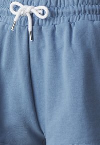 Light blue cotton shorts with an elastic waistband, featuring a white drawstring with silver metal tips and a soft texture.