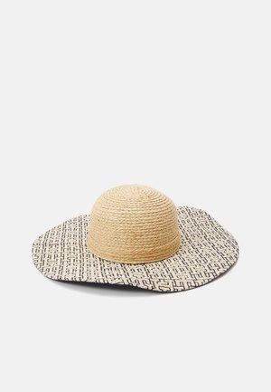 Wide-brimmed sun hat with woven beige crown and patterned black-and-white fabric brim laid flat on a white surface.