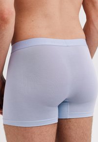 Helle blaue Boxershorts aus glattem Stoff, mit einem weichen elastischen Bund mit Prägung, geschnitten für eine enganliegende Passform.