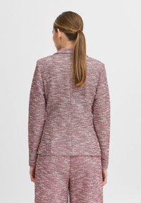 Gewebter Stoffanzugjacke in Rosa und Weiß, taillierter Schnitt mit subtiler Textur, mit geschlitztem Kragen und einem leichten Schlitz hinten.