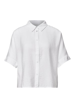 Camicia bianca con colletto e bottoni a pressione rigati in argento, indossata da una persona con capelli biondo chiaro visibili ai bordi.