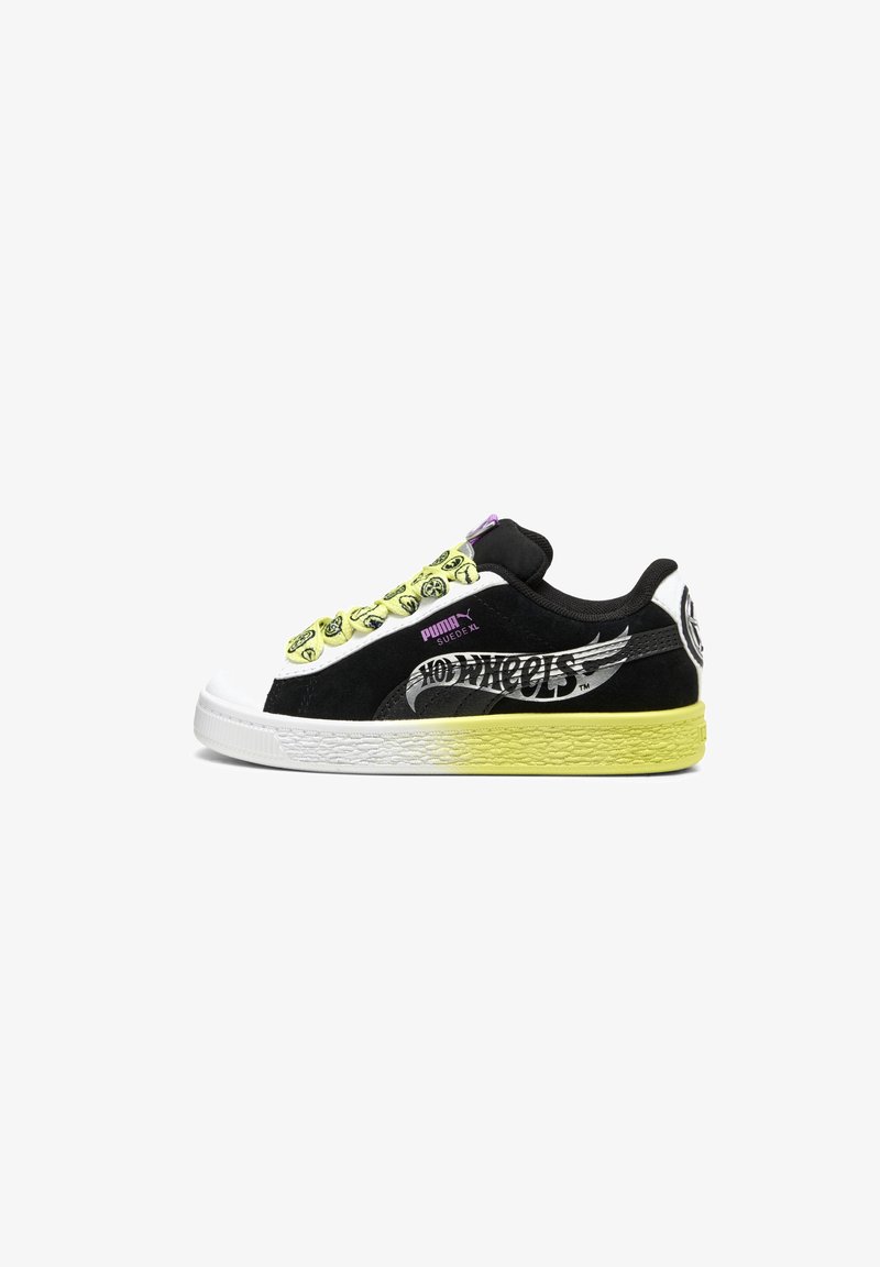 Baskets Puma Suede XL noir et blanc avec semelle jaune, logo Hot Wheels sur le côté et lacets jaunes avec des icônes de smileys noirs.