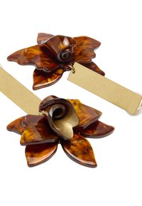 Para broszek kwiatowych z ciemno-bursztynowymi pétalami z żywicy i różowymi akcentami, z złotą metką przymocowaną do każdej z nich.