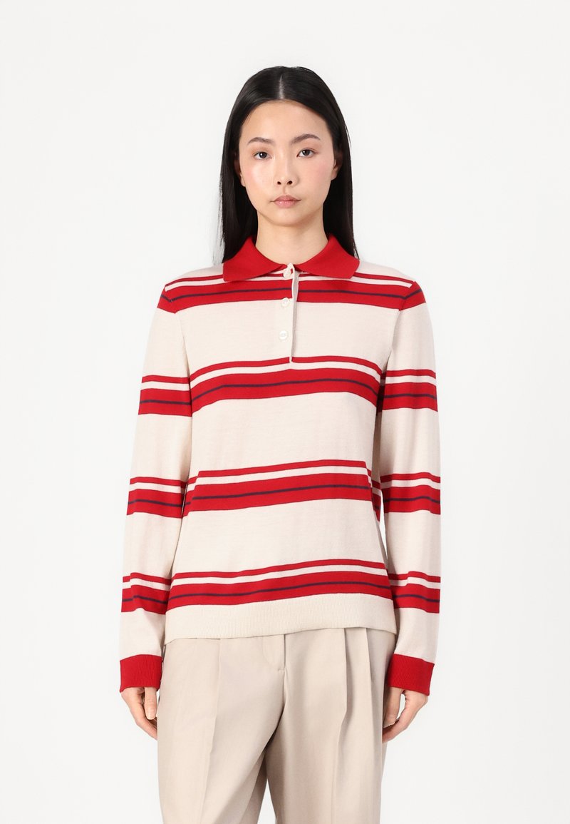 Polo à manches longues en beige avec des rayures rouges, doté d'un col rouge et d'une patte de boutonnage à trois boutons, fabriqué en matériau tricoté doux.