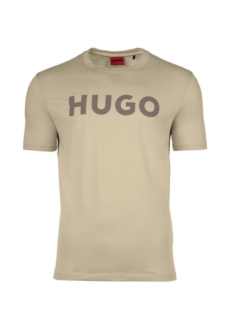 Béžové tričko vyrobené z bavlny, s kulatým výstřihem a krátkými rukávy. Velké logo "HUGO" v tmavě šedé barvě přes prsa.