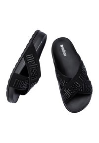 Ciabatte nere con fasce spesse e testurizzate, caratterizzate dal logo "Melissa" stampato. Suola in gomma con profilo basso e finitura liscia.