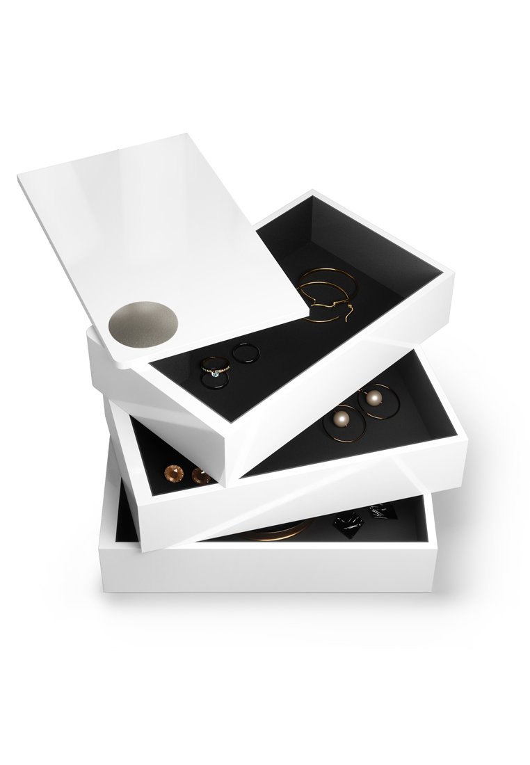 Organizador de joyas blanco con tres cajones apilados; el interior presenta forro negro; hardware circular notable en el cajón superior; diseño geométrico moderno.