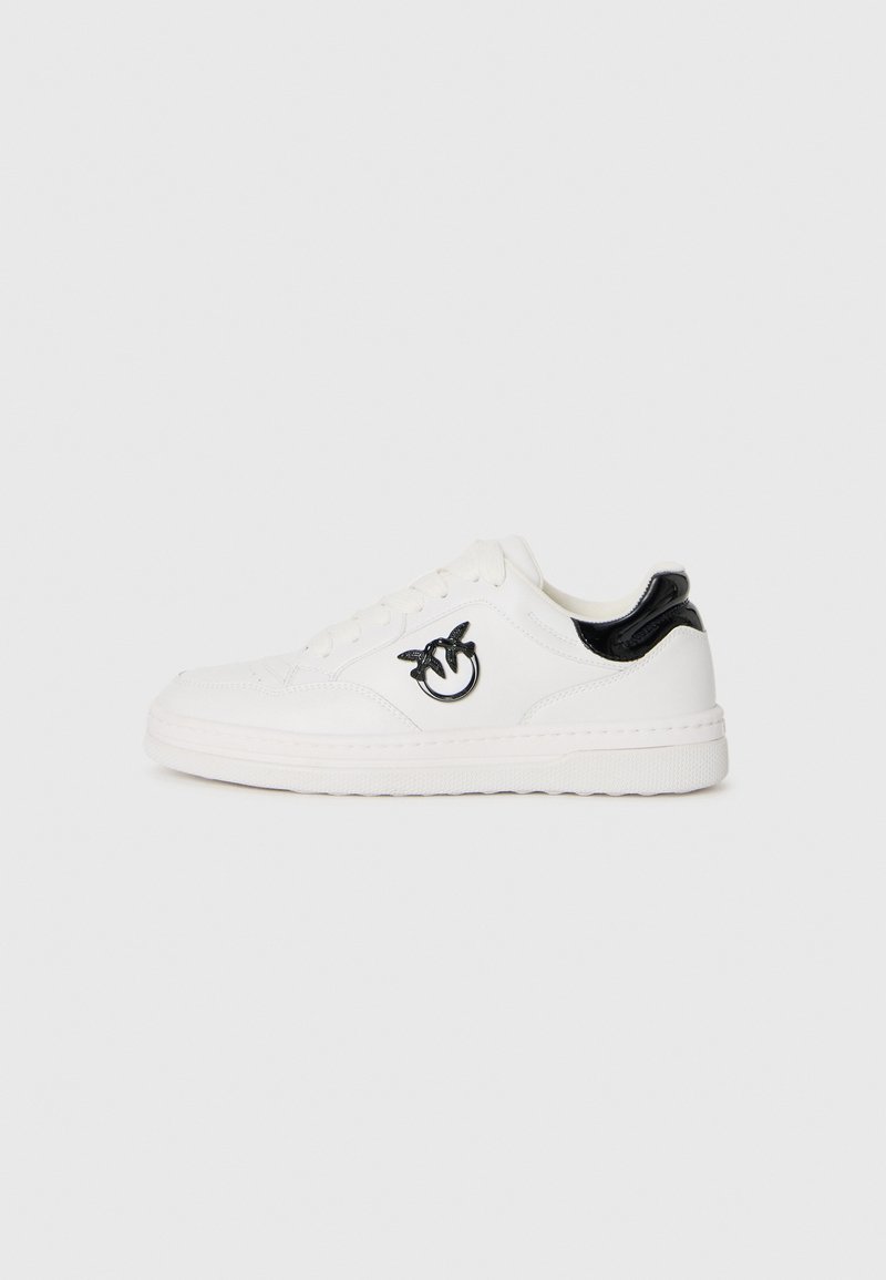 Białe sneakersy z gładkiej skórzanej cholewki, czarny lakierowany akcent na pięcie oraz okrągłe logo wyszyte po bokach. Okrągły wzór podeszwy.