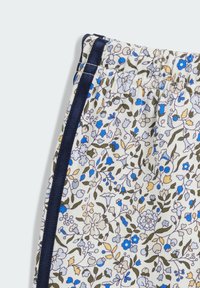 Tessuto con motivo floreale caratterizzato da fiori blu, gialli e verdi su uno sfondo chiaro. Presenta una vita e dettagli a trim in blu navy.