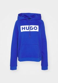 Niebieska bluza z kapturem wykonana z bawełny, z przednią kieszenią, ozdobiona dużym białym logo „HUGO” na piersi oraz regulowanym kapturem ze sznurkiem.