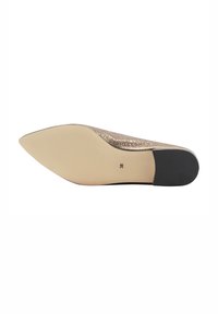 Puntige platte schoen met een glinsterende gouden bovenkant, een gladde nude zool en een zwarte accent op de hak. Maat 38 gemarkeerd op de zool.
