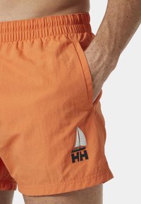 Oranžové plavkové šortky s elastickým pasem, bočními kapsami a logem plachetnice. Lehká tkanina s hladkým povrchem.