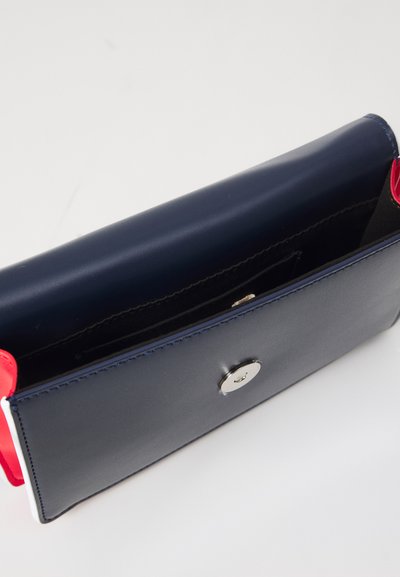 Portafoglio in pelle blu navy con dettagli rossi, caratterizzato da una texture liscia, una chiusura a scatto e un design semplice e rettangolare. Interno foderato in nero.