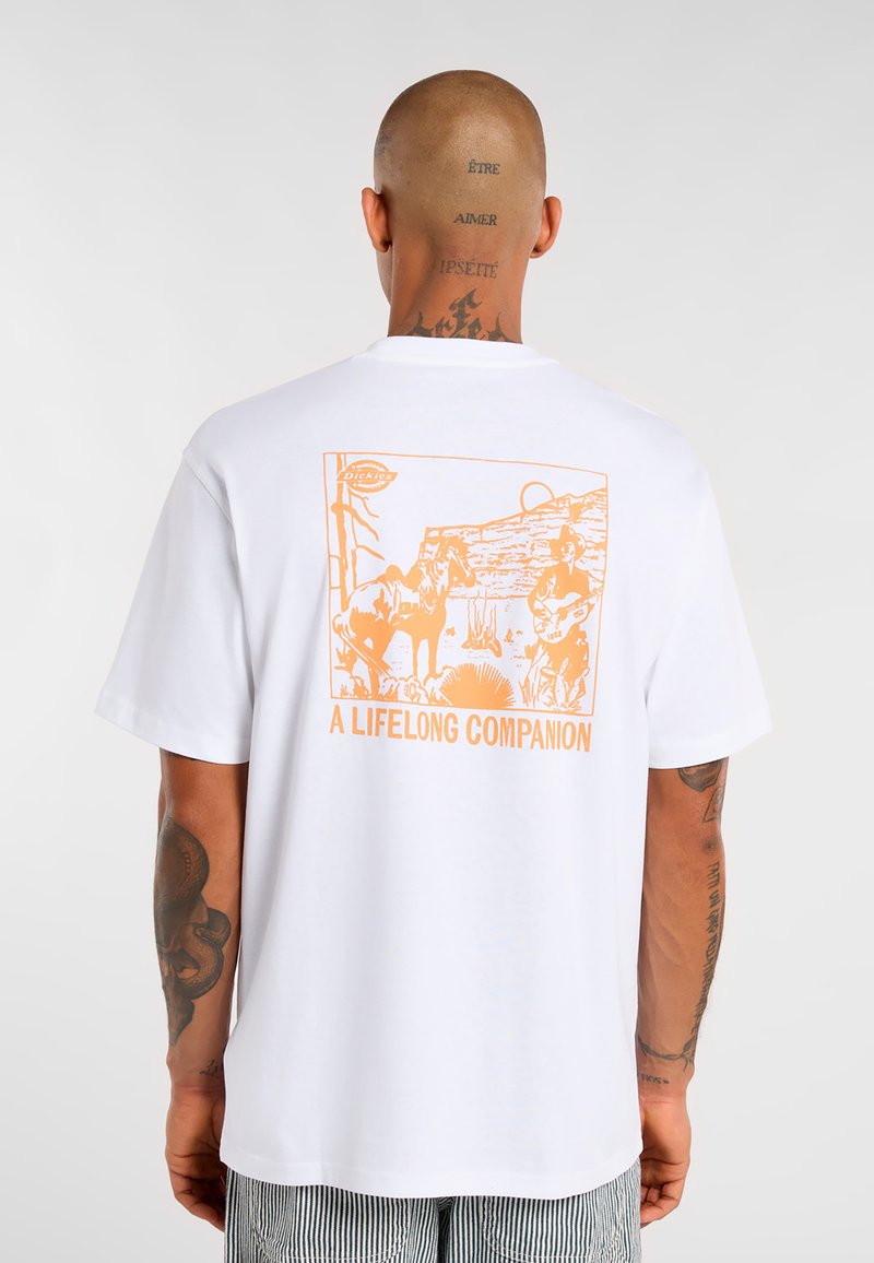 Bílý bavlněný tričko s velkým oranžovým grafickým designem zobrazením koní a osoby s kytarou, označené jako "CELOŽIVOTNÍ SPOLEČNÍK."