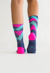 Mehrfarbige kniehohe Socken mit einem geometrischen Muster in Marineblau, Aqua, Pink und Dunkelblau; nahtlose Spitze und gerippter Rand für zusätzlichen Komfort.