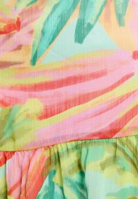 Tessuto leggero con un motivo astratto multicolore in tonalità di rosa, verde e arancione. Texture plissettata sull'orlo.