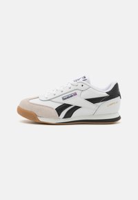 Hvite lær sneakers med svarte detaljer og semsket skinn. Har snøringslukking, gummisåle og tekstilforing. "CAMPIO XT"-merke på hælen.