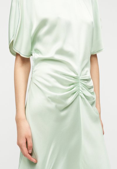 Φόρεμα από σατέν σε ανοιχτό πράσινο χρώμα με κοντά μανίκια, με λεπτομέρεια μπούκλας στη μέση και αντίθετη ραφή κατά μήκος των άκρων.