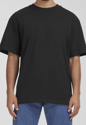 T-shirt en coton noir avec col rond, manches courtes et coupe décontractée, présentant une texture lisse sans motifs ou dessins visibles.