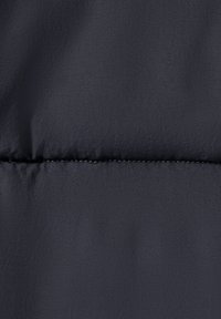 Tessuto puffer blu navy con una texture liscia e una leggera lucentezza, caratterizzato da una cucitura orizzontale con dettagli di cucitura a contrasto.