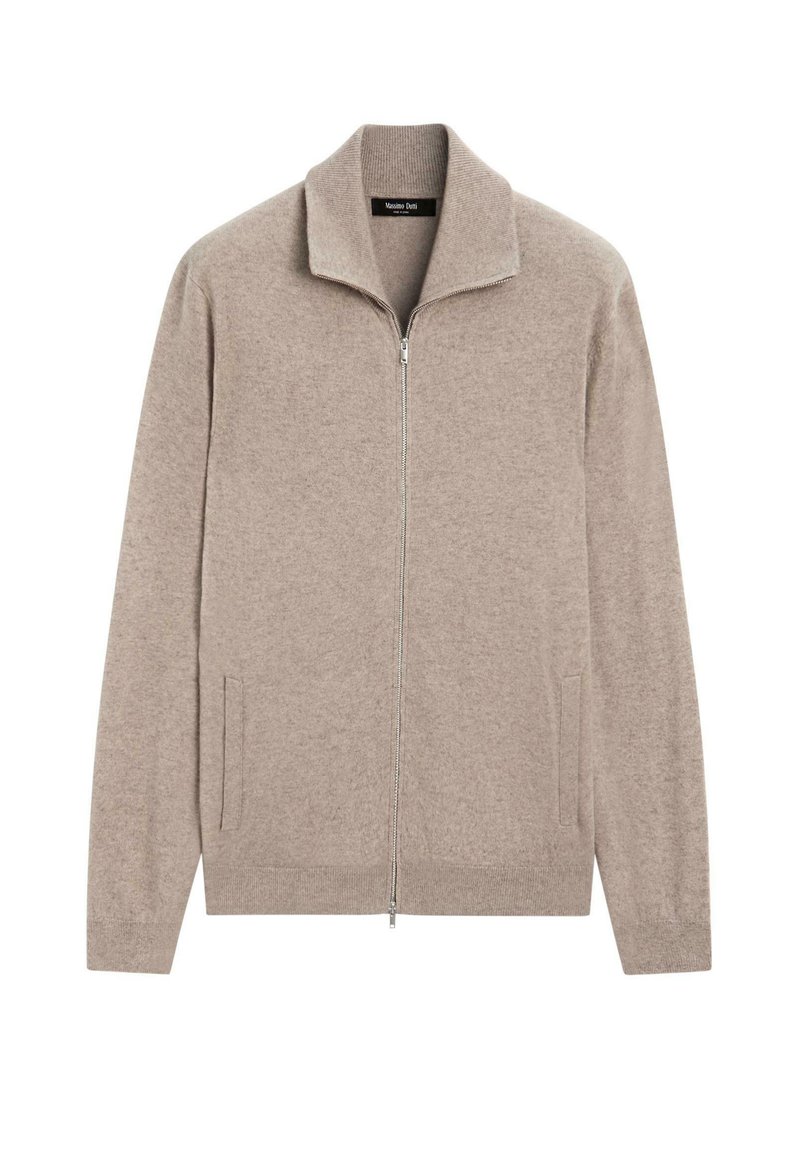 Helle beige Zip-Jacke aus weichem Strickstoff. Besondere Merkmale sind der hohe Kragen, zwei seitliche Taschen und gerippte Details an den Bündchen. Minimalistisches Design.