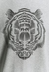T-shirt grigio con una grafica di testa di tigre nera, realizzata con un design intricato. Il design include linee fini e texture dettagliate.