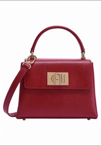 Borsa a mano in pelle rossa con forma strutturata, manico superiore e tracolla removibile. Presenta una chiusura con logo in metallo dorato sulla parte anteriore.