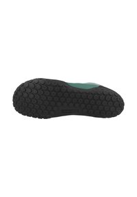 Black rubber shoe sole with a hexagonal tread pattern, featuring a smooth, green upper edge, designed for traction and stability.