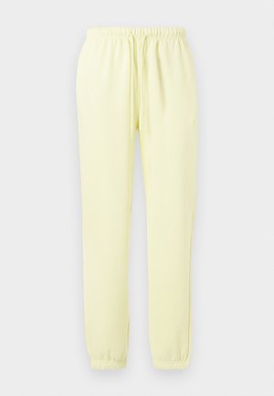 Pantaloni de trening galbeni deschis, dintr-un material moale, având un talie ajustabilă cu șnur și manșete elastice la glezne.