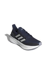 Zapatilla deportiva azul marino con parte superior de malla transpirable, tres rayas plateadas y una suela blanca acolchada con detalles texturizados.