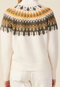 Pletený svetr v krémové barvě s texturovaným finišem. Vyznačuje se geometrickým vzorem v žluté, zelené a světle šedé na ramenou. Vysoký límec.