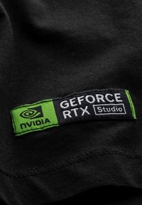 Zwarte stof met een rechthoekige patch erop gestikt, met "NVIDIA" in het wit en "GEFORCE RTX Studio" in het zwart op een groene achtergrond.