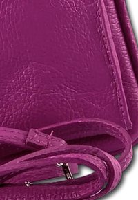 Fuchsia leren handtas met een gestructureerd ontwerp en een textuur oppervlak, voorzien van een afneembare schouderriem. Elegante stiksels en verfijnde accenten.