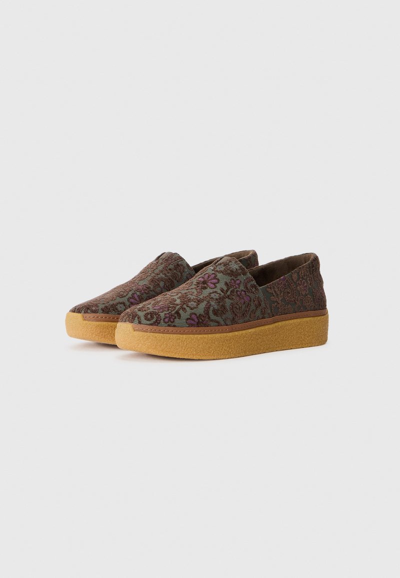 Zapatillas de slip-on con un patrón floral texturizado en verde y marrón, con una suela de goma gruesa y un detalle de costura en contraste.