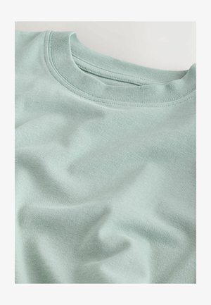 Hellmintgrünes Baumwoll-T-Shirt mit einem gerippten Rundhalsausschnitt und leicht zerknitterter Textur, das weiches Gewebe zeigt.