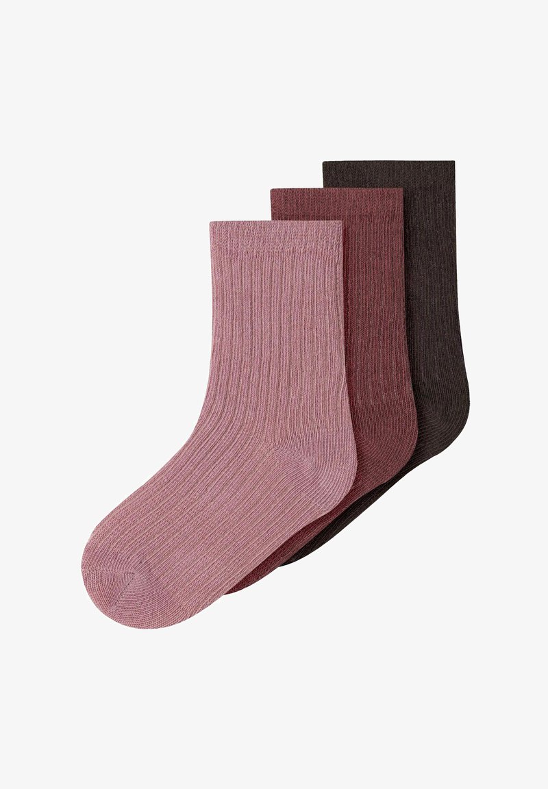 Trois paires de chaussettes côtelées en tricot rose, bordeaux et marron foncé, empilées en chevauchement sur un fond blanc.
