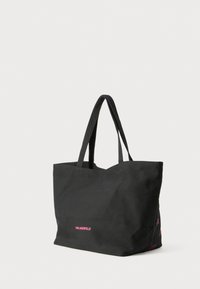 Black tote bag with dual handles and small pink "Karl Lagerfeld" text on front, shown against a plain light background.
