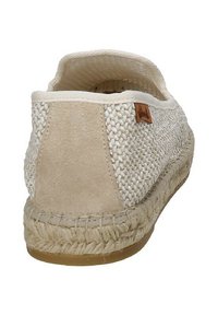 Espadrilla beige con tomaia in tessuto intrecciato, dettagli in suede e suola in juta intrecciata. Presenta un design piatto e dettagli cuciti sui bordi.