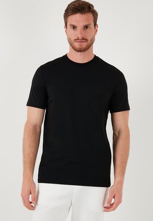 Tricou scurt de culoare neagră, din bumbac, cu guler rotund, design ajustat și textură netedă. Fără modele sau accente vizibile.