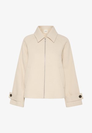 Beige jacka med dragkedja framtill, stor krage, ribbad textur och sidofickor. Manschetterna har en knapppynt.