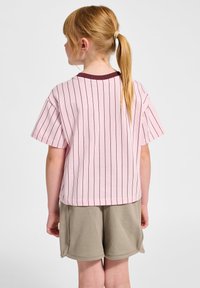 Kortärmad rosa t-shirt med vertikala vinröda ränder, rund hals och avslappnad passform. Matchat med ljusgrå shorts.