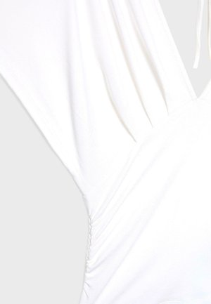 White dress featuring a deep V-neckline, short sleeves, and ruched side detailing. Made from soft, lightweight fabric.