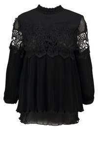 Černá blůza s dlouhými rukávy, zdobená jemnou krajkou na ramenou, skládáním v oblasti hrudníku a vysokým límcem. Měkká textura.