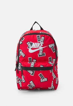 Rode stoffen rugzak met zwarte rits en accenten. Voorzien van herhaalde witte Nike-logo's en tekst. Inclusief een voorzak en handvat aan de bovenkant.