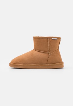 Czarne zamszowe botki do kostki z zaokrąglonym noskiem, miękką wyściółką, przeszyciami oraz gumową podeszwą. Widoczna metka marki z boku.