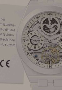 Weißer Wristwatch mit transparentem Zifferblatt, das komplexe mechanische Arbeiten, silberne Zahnräder und blaue Akzente zeigt. Besitzt klare Stundenmarkierungen.