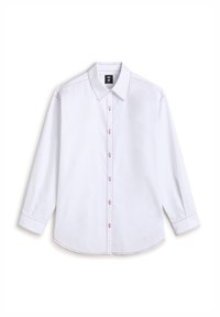 White cotton shirt with long sleeves, pointed collar, button closure, and contrast red stitching along the seams and cuffs.