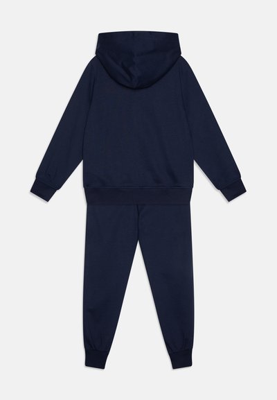 Temno modra kapuca in set hlač jogger iz mehkega bombažnega materiala, s kapuco, rebrastimi manšetami in pasom, preprostega dizajna.